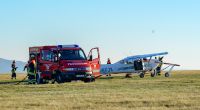 Feuerwehrleute stehen nach dem Flugunfall in Hessen neben dem verunglückten Sportflugzeug.