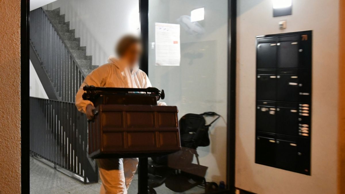 Eine Mitarbeiterin der Spurensicherung trägt einen Kasten aus einem Haus im Stadtteil Eberstadt. In einer Wohnung in Darmstadt waren Leichenteile gefunden worden. (Foto)