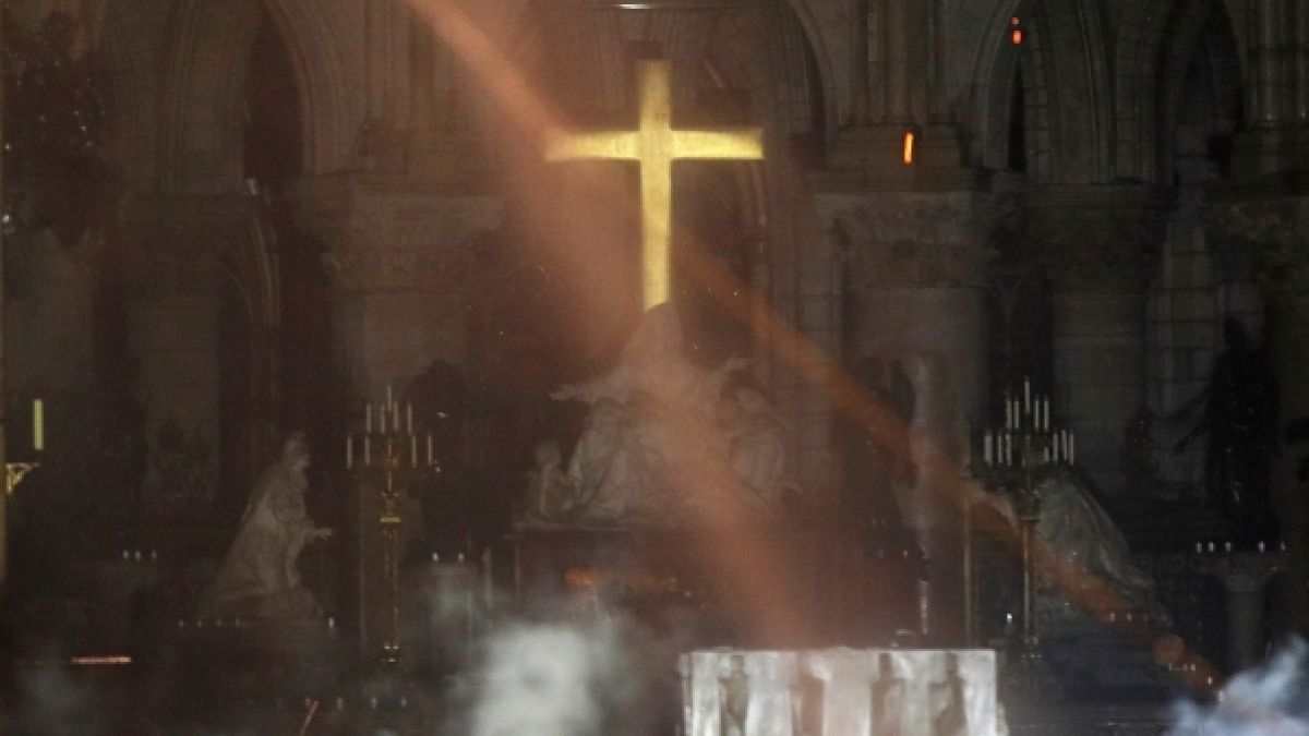 Der Altar der Kathedrale Notre-Dame ist am 15.04.2019 bei einem verheerenden Feuer von Rauch umgeben (oben) und der damalige Erzbischof von Paris, Andre Vingt-Trois, bei einer Messe in der Kathedrale 2015. (Foto)