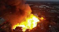 Helle Flammen schlagen aus einem Gebäudekomplex in Mönchengladbach im Stadtteil Eicken (Luftaufnahme mit Drohne). Das Feuer war in dem Areal ausgebrochen, in dem neben einer Schreinerei auch noch weitere Betriebe untergebracht sind.