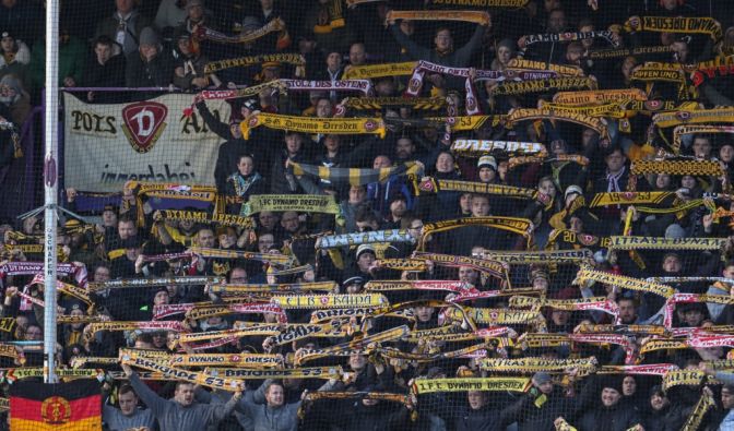 Mit ihren Schals in der Luft unterstützen die Fans von Dynamo Dresden ihren Verein. (Symbolbild)