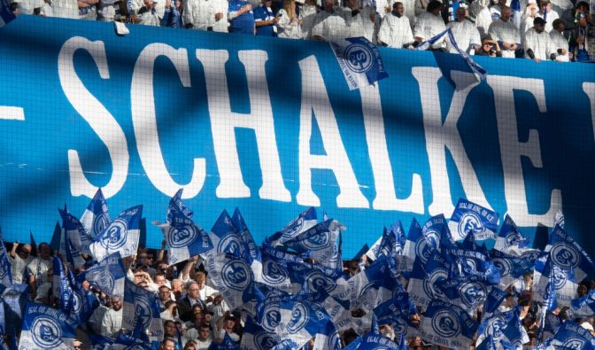 Mit wehenden Fahnen feuern die Fans von Schalke 04 ihre Mannschaft an. (Symbolbild)