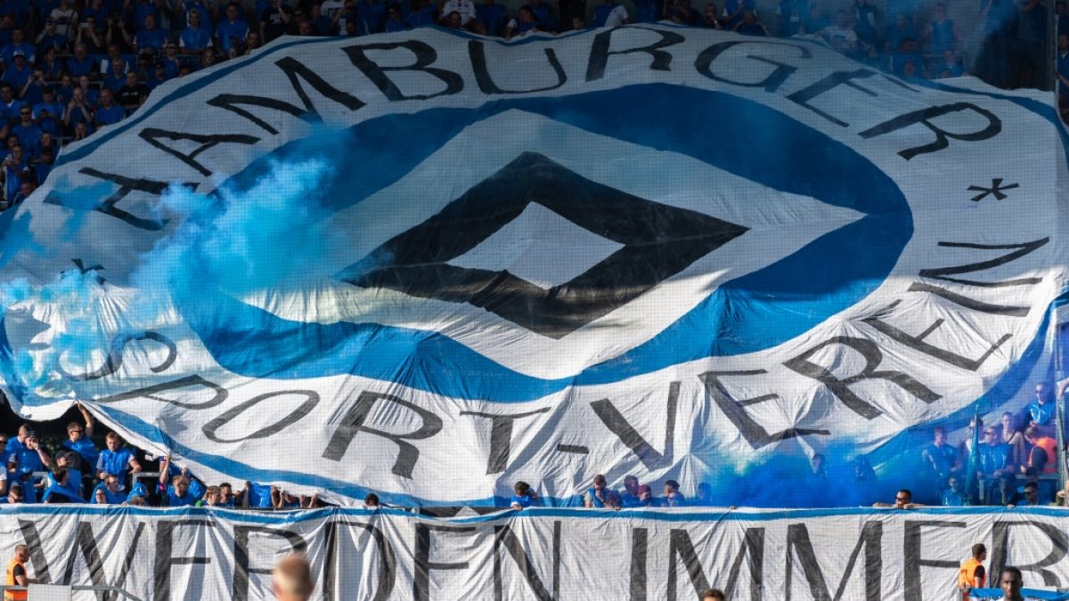 Unter ihrem blauen Wappen feuern die Fans des Hamburger SV ihren Verein an. (Symbolbild) (Foto)