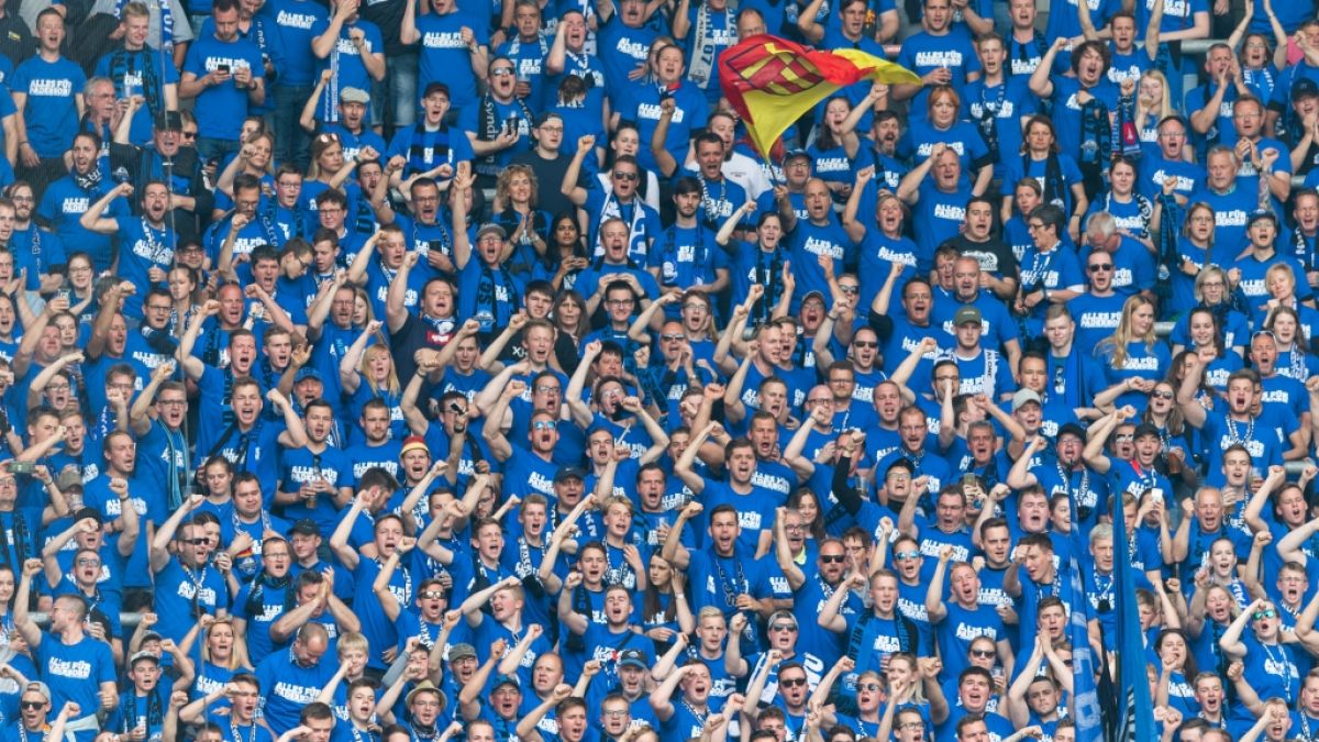 Mit blauen Shirts zeigen die Fans auf der Tribüne ihre Unterstützung für den SC Paderborn. (Symbolbild) (Foto)