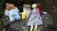 Eine Puppe und Kerzen liegen auf einem Felsen vor dem Haus in Solingen, in dem die junge Mutter ihre fünf Kinder getötet haben soll.