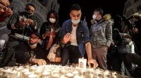 Menschen zünden Kerzen auf der Straße vor der Kirche Notre Dame für die Opfer einer Messerattacke an.