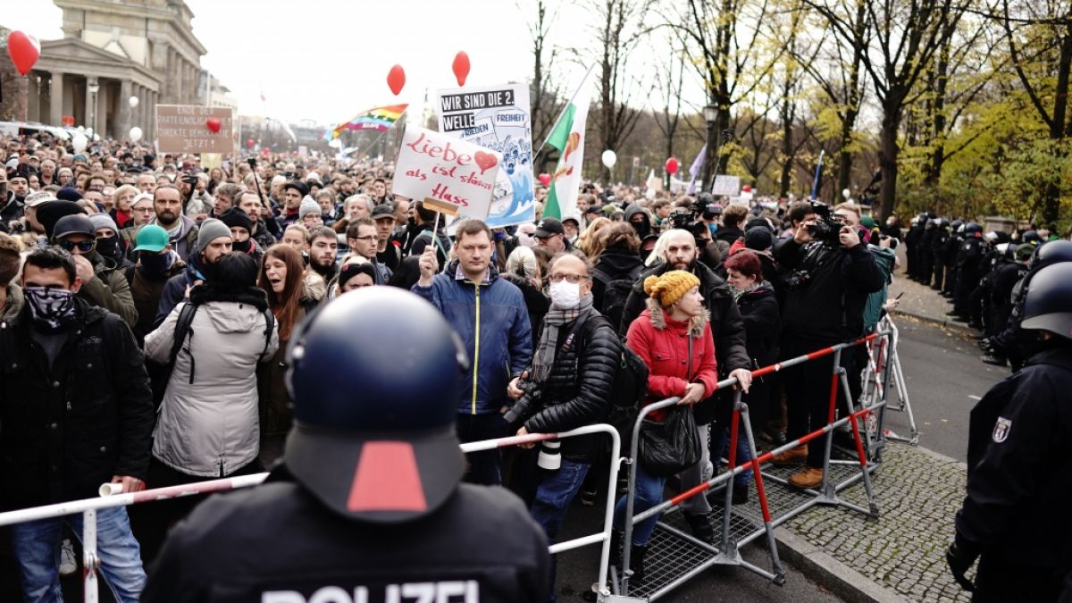 Teilnehmer einer Demonstration gegen die Corona-Einschränkungen der Bundesregierung stehen nach dem Brandenburger Tor an einer Absperrung Polizisten gegenüber. (Foto)