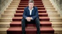 Robert Habeck, Wirtschaftsminister und Kanzlerkandidat der Grünen, sitzt am Rande eines Interviews für ein Foto auf einer Treppe.