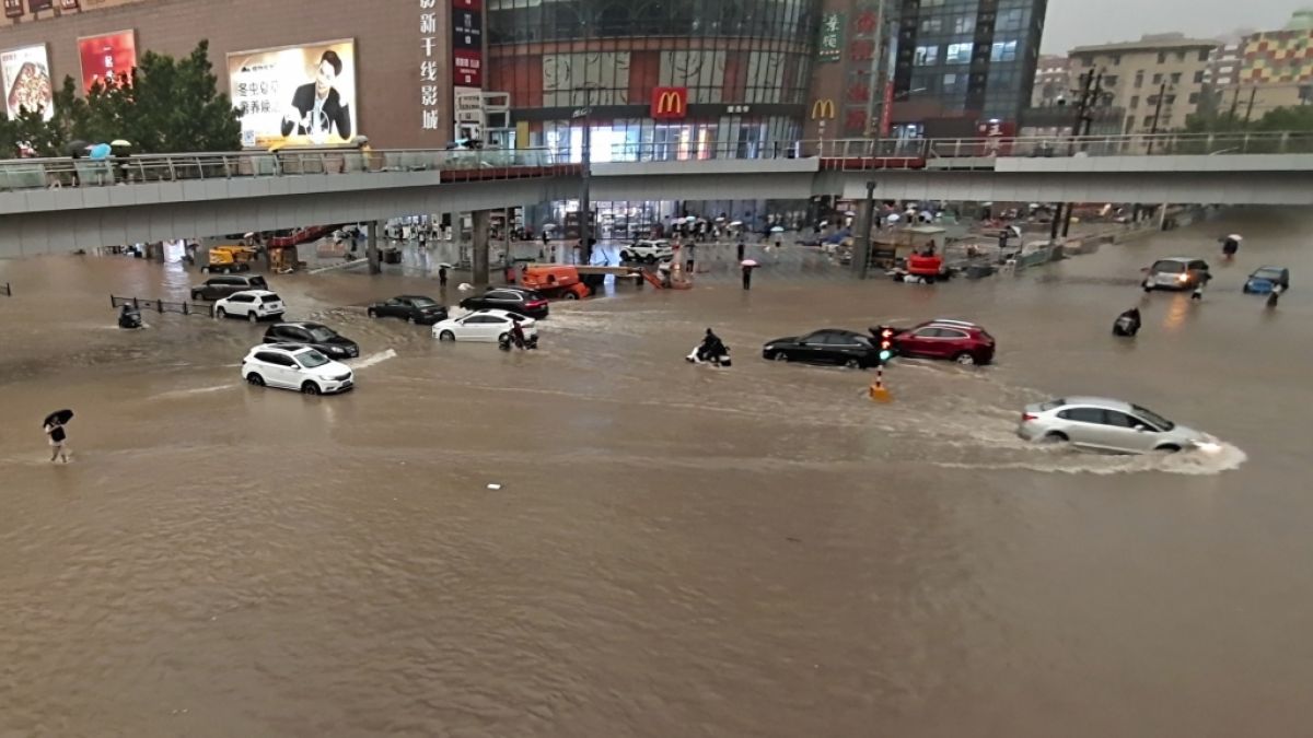 Fahrzeuge stehen in der zentralchinesischen Provinz Henan auf einer überfluteten Straße. (Foto)