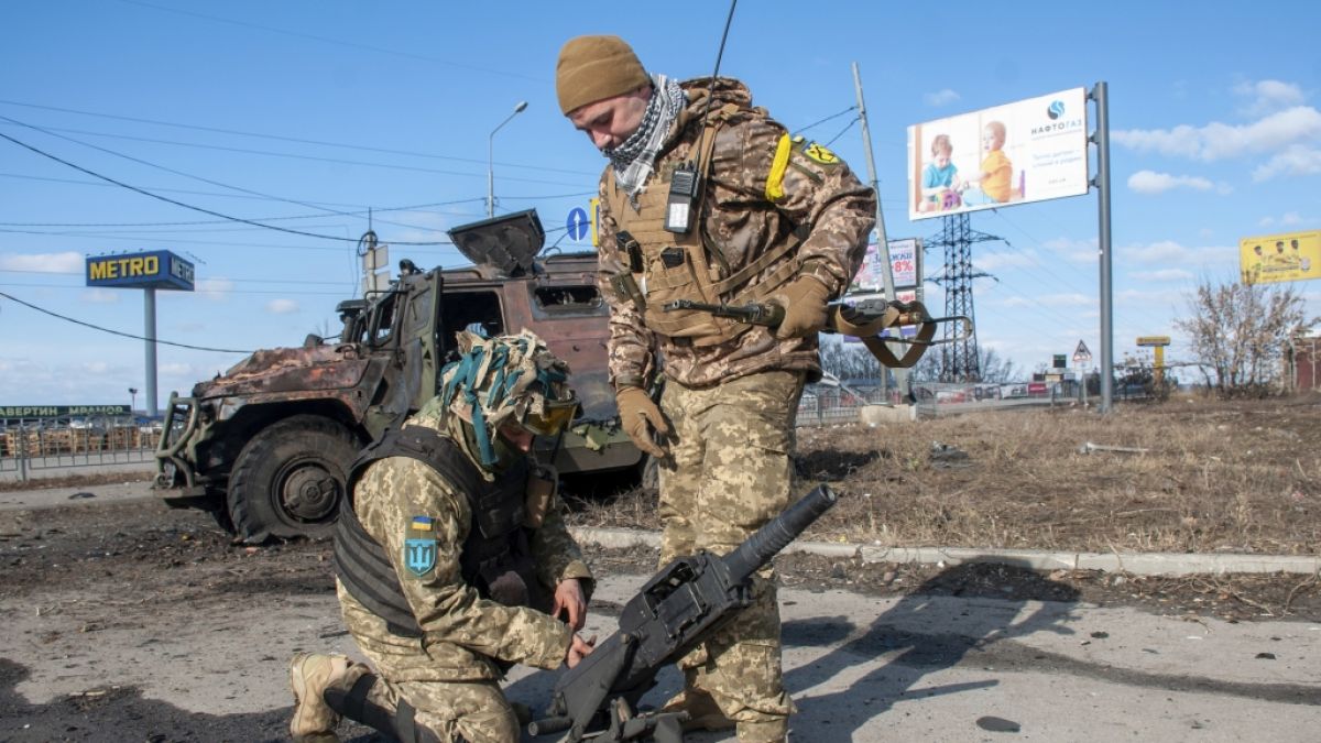 Ukrainische Soldaten hantieren mit Ausrüstung aus einem beschädigten Militärfahrzeug nach Kämpfen in Charkiw. (Foto)