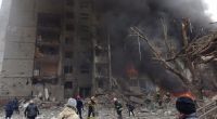 Feuerwehrleute löschen ein Feuer in einem beschädigten Stadtzentrum nach einem russischen Luftangriff.