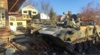 Ein Panzer der russischen Armee steht in den Trümmern eines zerstörten Hauses.