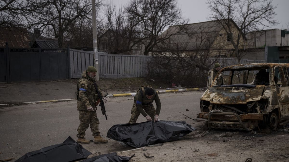 Zwei ukrainische Soldaten bergen die Überreste von vier getöteten Zivilisten aus einem verkohlten Fahrzeug in Butscha. (Foto)