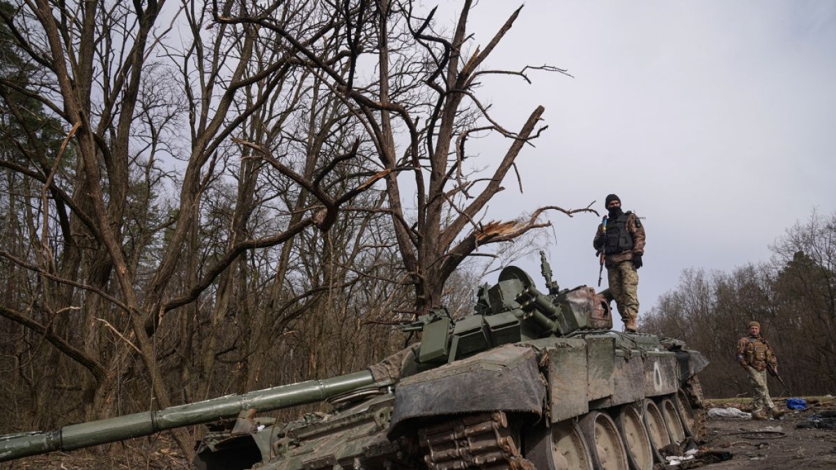 Ukrainische Soldaten posieren auf einem zerstörten Russen-Panzer. (Foto)