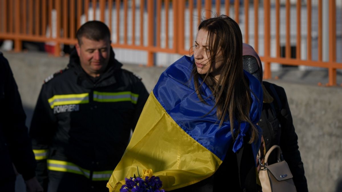Eine Geflüchtete trägt eine ukrainische Fahne, nachdem sie mit einer Fähre die Grenze überquert hat. (Foto)