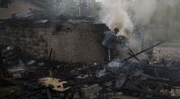 Ein Mann versucht, nach einem russischen Bombardement eines Wohnviertels, ein Feuer zu löschen.