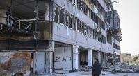 Ein Anwohner geht an einem beschädigten Gebäude in einem Gebiet unter der Regierung der Volksrepublik Donezk im Osten der Ukraine vorbei.