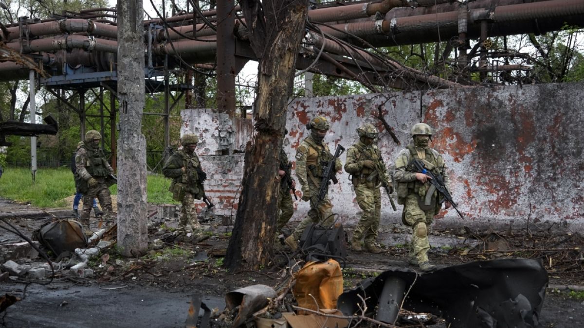 Russische Soldaten gehen durch einen zerstörten Bereich des Iljitsch Eisen- und Stahlwerks Mariupol. Dieses Foto wurde während einer vom russischen Verteidigungsministerium organisierten Reise aufgenommen. (Foto)