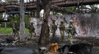 Russische Soldaten gehen durch einen zerstörten Bereich des Iljitsch Eisen- und Stahlwerks Mariupol. Dieses Foto wurde während einer vom russischen Verteidigungsministerium organisierten Reise aufgenommen.