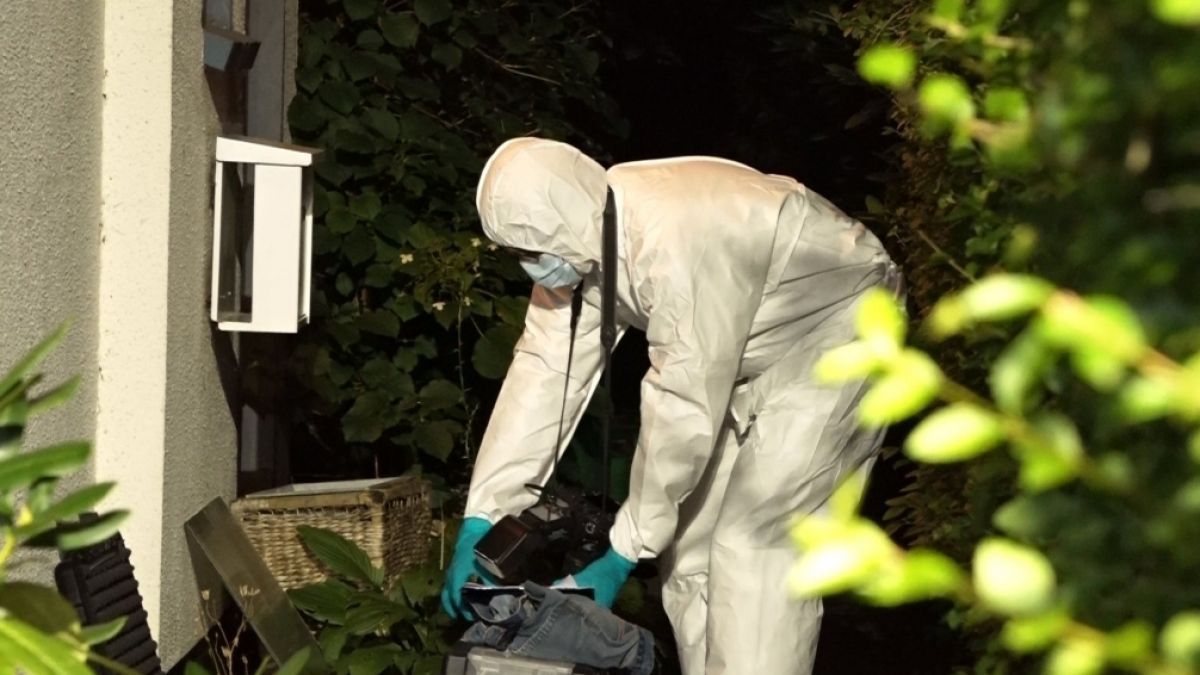 Ein Mitarbeiter der Spurensicherung arbeitet im Eingangsbereich eines Einfamilienhauses in Delmenhorst, vor dem die Leiche einer 80-jährigen Frau gefunden worden war. (Foto)