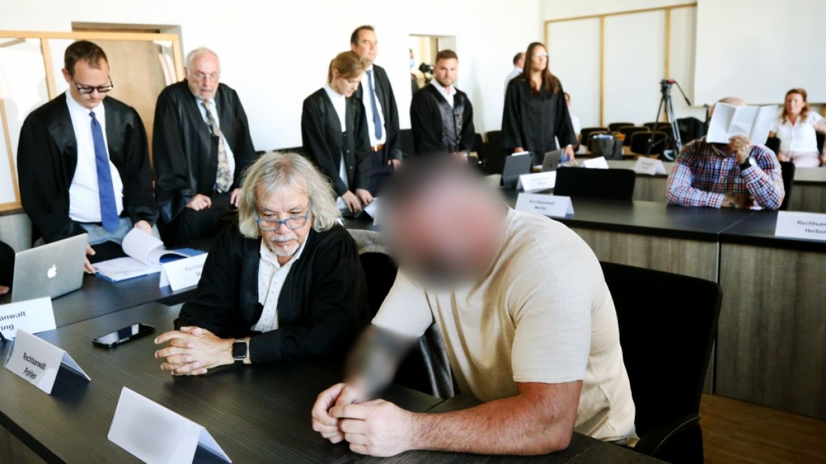 Zwei von sechs Angeklagten (vorne r. und hinten r.) im Duisburger Landgericht vor Beginn des Prozesses um eine tödliche Bestrafungsaktion im Rocker-Milieu. (Foto)