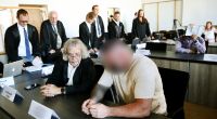 Zwei von sechs Angeklagten (vorne r. und hinten r.) im Duisburger Landgericht vor Beginn des Prozesses um eine tödliche Bestrafungsaktion im Rocker-Milieu.