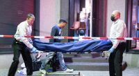 Bestatter tragen die Leiche eines Opfers aus einer Bar in Offenbach.