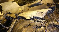 Trümmer des abgestürzten Kampfflugzeugs liegen in der Nähe eines beschädigten Gebäudes in Jeisk.