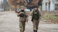Zwei ukrainische Soldaten patrouillieren in einer Stadt im Gebiet Cherson in der Nähe der Frontlinie.