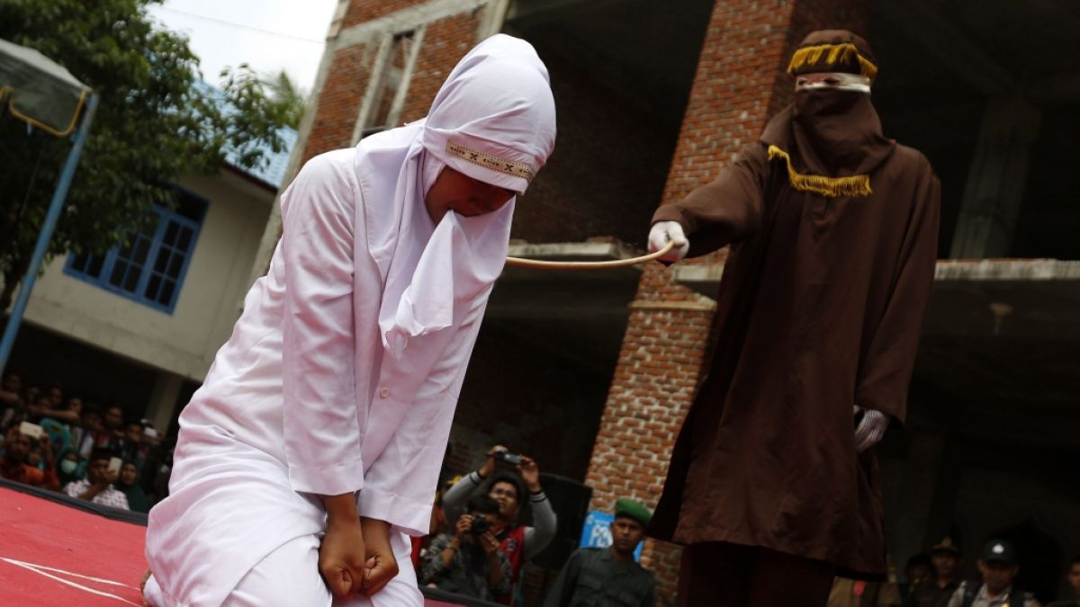 Eine Frau wird in Banda Aceh, Indonesien, wegen außerehelichem Sex mit Peitschenhieben bestraft (2016). (Foto)