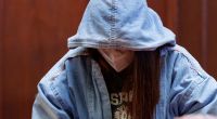 Die angeklagte 17-jährige junge Frau sitzt im Sitzungssaal im Landgericht.