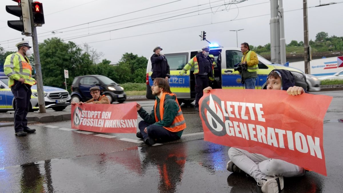 Polizisten sprechen mit Demonstranten der Aktivistengruppierung "Letzte Generation", die eine Hauptverkehrsstraße in Stuttgart blockieren. (Foto)