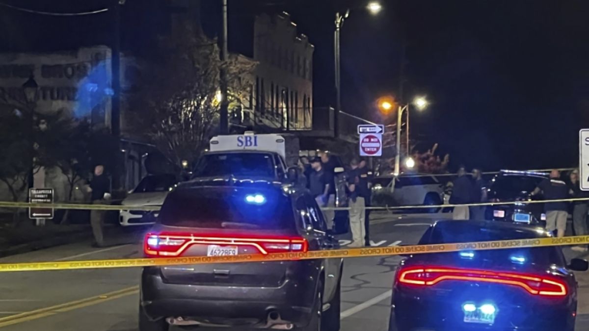 Menschen und Polizeiautos stehen am Tatort. Bei Schüssen während einer Geburtstagsparty im US-Bundesstaat Alabama sind mehrere Menschen getötet worden. (Foto)