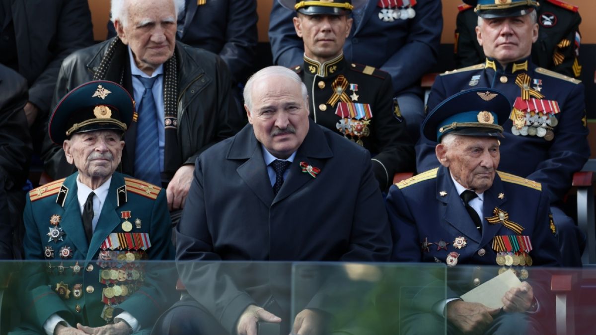 Der belarussische Präsident Alexander Lukaschenko (M) beobachtet neben Veteranen die Militärparade zum Tag des Sieges auf dem Roten Platz in Moskau. (Foto)
