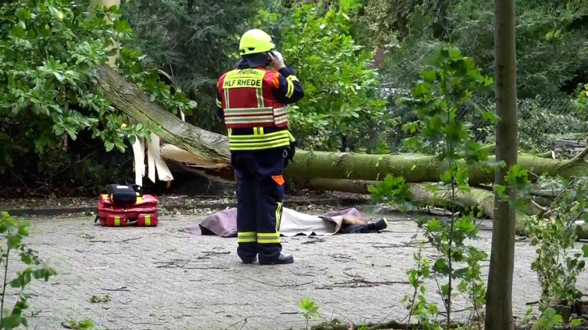 Ein Feuerwehrmann steht vor der abgedeckten Leiche einer Frau, die während des Sturms Poly von einem umgestürzten Baum tödlich verletzt wurde. Nach Polizeiangaben erlag die Frau noch vor Ort ihren Verletzungen. (Foto)