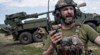 Ein ukrainischer Soldat spricht über Funk mit seinem Team, bevor eine Panzerhaubitze auf russische Stellungen abfeuert.