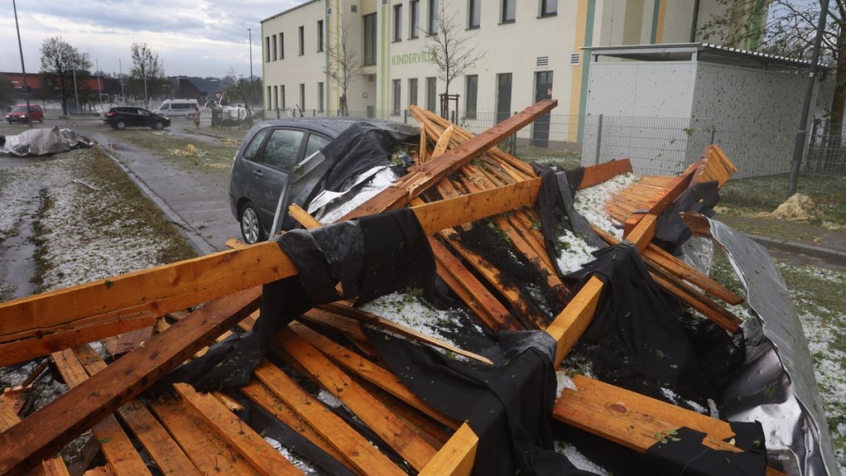Ein vom Sturm abgetragenes Dach eines Seniorenheims liegt in Kissing bei Augsburg in Bayern auf einem Parkplatz auf einem Auto. (Foto)