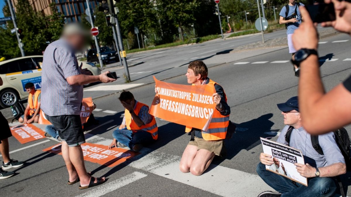 Klimaaktivisten der "Letzten Generation" werden in München von einem Mann beschimpft. (Foto)