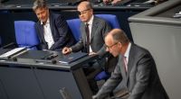Bundeskanzler Olaf Scholz beäugt Friedrich Merz bei der Generaldebatte im Bundestag.