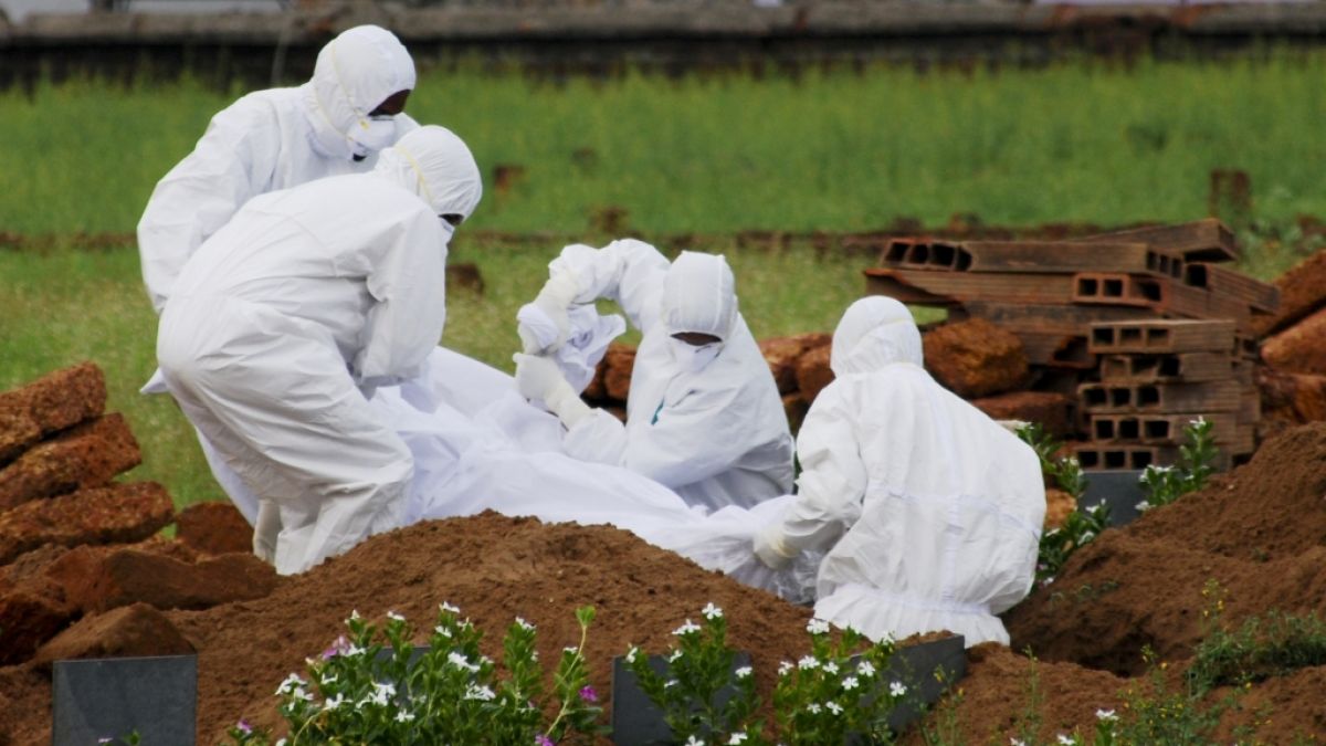 Indische Rettungssanitäter in Schutzanzügen begraben ein Opfer, das nach einer Infektion mit dem gefährlichen Nipah-Virus verstarb. (Foto)