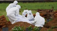 Indische Rettungssanitäter in Schutzanzügen begraben ein Opfer, das nach einer Infektion mit dem gefährlichen Nipah-Virus verstarb.