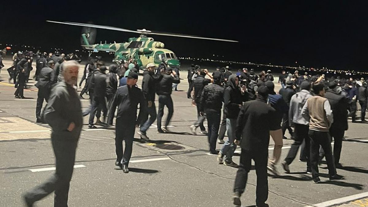 Menschen laufen und rufen antijüdische Parolen auf einem Flugfeld des Flughafens in Machatschkala in Russland. (Foto)