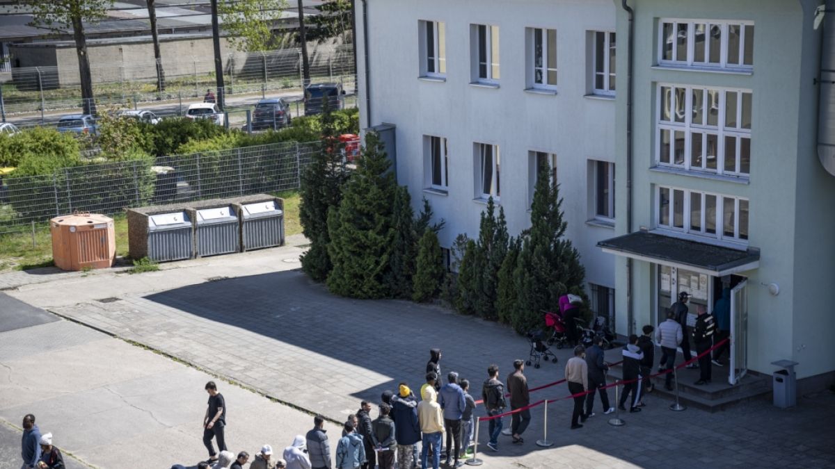 Migranten stehen in einer Schlange in einer Erstaufnahme-Einrichtung. (Foto)