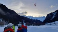 Menschen beobachten einen Einsatz der italienischen Bergrettung in der Nähe von Ratschings in Südtirol. Eine deutsche Gruppe wurde von einer Lawine erfasst, für einen 21-Jährigen kam jede Hilfe zu spät.