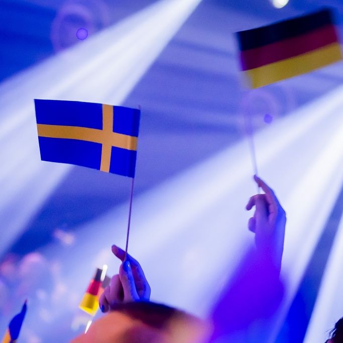 Zuschauer halten beim deutschen ESC-Vorentscheid die Fähnchen von Deutschland und Schweden hoch. Der Eurovision Song Contest 2024 findet in Malmö in Schweden statt.