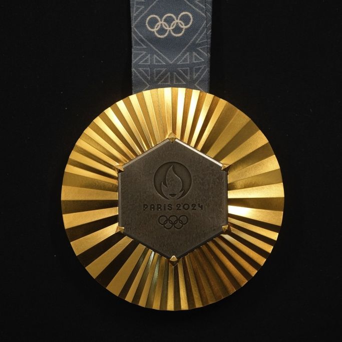 Die olympische Goldmedaille 2024: Ein sechseckiges, poliertes Eisenstück vom Eiffelturm wird in jede Gold-, Silber- und Bronzemedaille eingebettet, die den Olympia-Athlet:innen um den Hals gehängt werden.