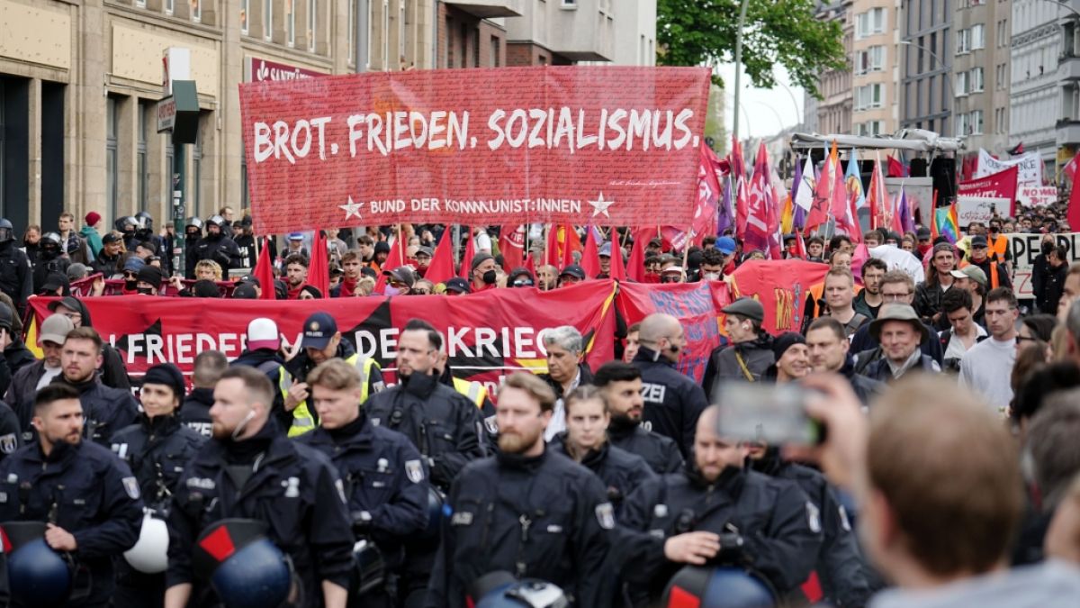 Demonstranten halten ein Banner mit dem Schriftzug "Brot. Frieden. Sozialismus." beim Protestzug hoch. (Foto)
