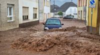 Ein Auto bahnt sich den Weg durch die Wassermassen. Extremer Starkregen hat am Pfingstsonntag in der rheinland-pfälzischen Stadt Kirn zu Überflutungen und Erdrutschen geführt.