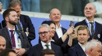 Außenministerin Annalena Baerbock (Mitte) und Bundeskanzler Olaf Scholz (Mitte oben) sitzen beim EM-Vorrundenspiel von Deutschland gegen die Schweiz auf der Tribüne. Kurz vor dem Achtelfinale gegen Dänemark sorgten ihre Social-Media-Posts für Kritik.
