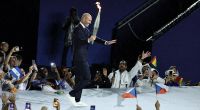 Fußball-Weltmeister Zinedine Zidane trägt die Olympische Fackel.